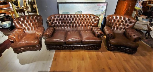 A pair of Chesterfield armchairs and a sofa