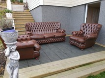 A pair of Chesterfield armchairs and a sofa