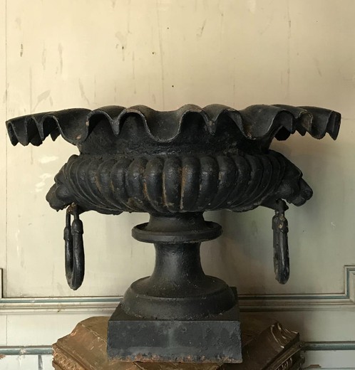 pair of cast iron garden urns two lion heads holding a ring in the mouth.
