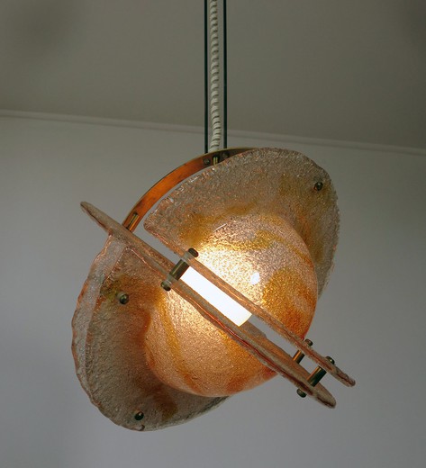 This Mazzega light fixture is a sculptural work of art. In terms of imagery it looks like a planet ablaze. It is ubstantial and impressive with colors ranging from orange to clear. Brass structure. rare and sought subject.