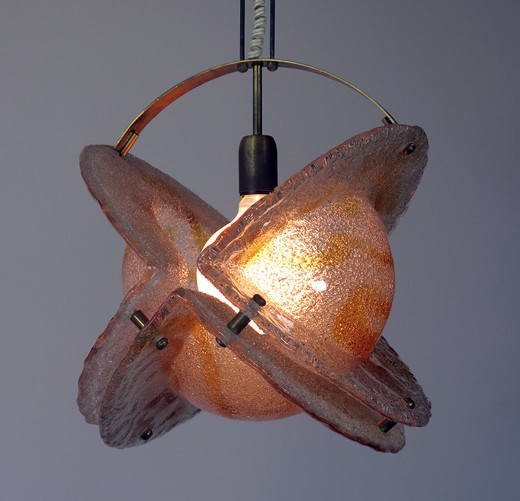 This Mazzega light fixture is a sculptural work of art. In terms of imagery it looks like a planet ablaze. It is ubstantial and impressive with colors ranging from orange to clear. Brass structure. rare and sought subject.