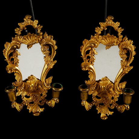 Antique twin mirrors with candlesticks in the style of Louis XV. They are made of gilded bronze. France, XIX century.