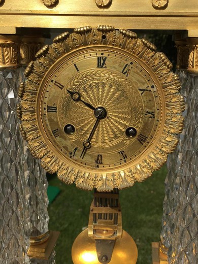Antique clock in the style of Charles X. Made of gilded bronze and glass. France, XIX century.