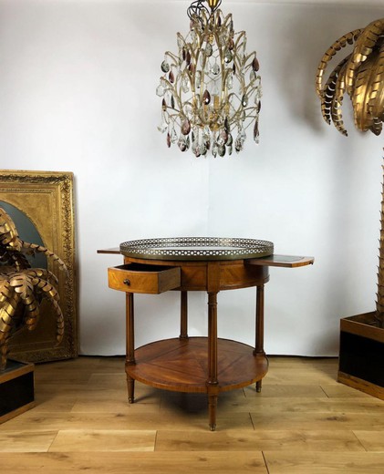 Antique table in the style of Louis XVI. It is made of wood. The table top is marble. It is decorated with a brass edging. France, XIX century.