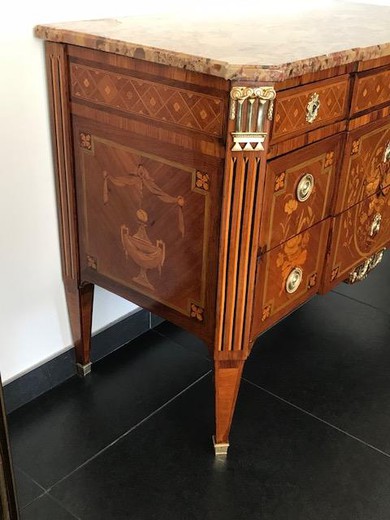 Antique chest of drawers in the style of Napoleon III. It is made of rosewood in marquetry technique. Decorated with patches of gilded bronze. The table top is marble. France, XIX century.