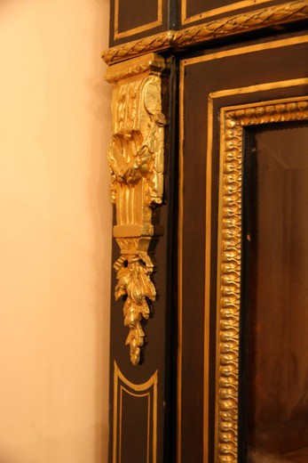 An antique corner showcase in the style of Napoleon III. Made of wood. Decorated with patches of gilded bronze. Marble pommel. France, XIX century.
