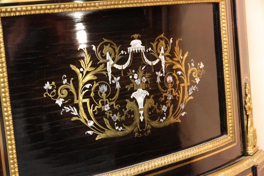 An antique corner showcase in the style of Napoleon III. Made of wood. Decorated with patches of gilded bronze. Marble pommel. France, XIX century.