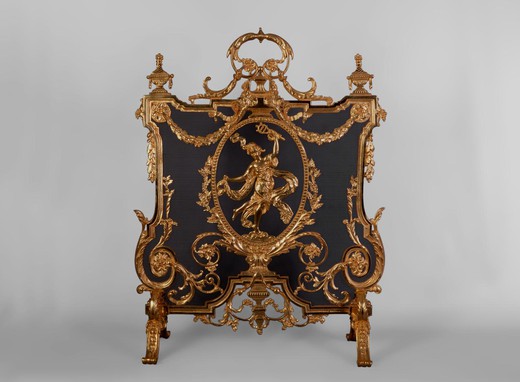 This antique Napoleon III style firescreen was made in the 19th century. In the center, in a richly ornamented medallion, a barefoot dancer wearing an antique dress made of draperies is represented. The firescreen has a very opulent decor typical of the N