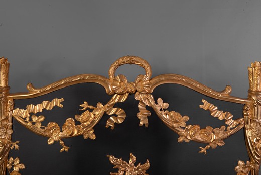 This antique Napoleon III style firescreen was made in the 19th century. Its opulent gilt bronze decor is characteristic of the Napoleon III style. Thus two quivers were carved on both sides while many branches of roses mixed with ribbons and draperies ad