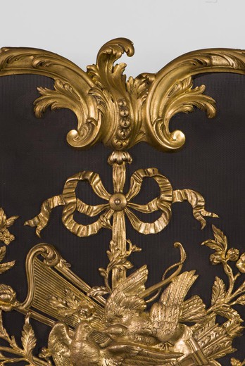 Antique fireplace screen in the style of Louis XV. It is made of gilded bronze. France, 1900s.
This magnificent fireplace screen is decorated with "Linka style" ornaments that combined the style of the Regency and the style of Louis XV in the era of Ar N