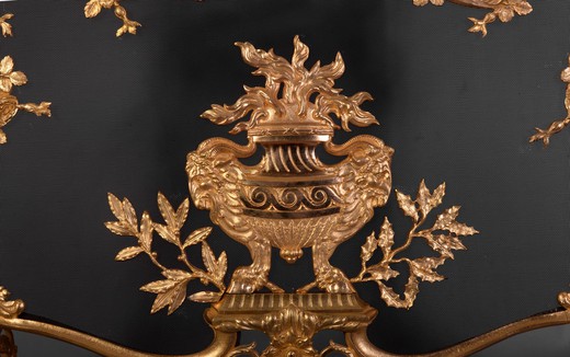 This antique Napoleon III style firescreen was made in the 19th century. Its opulent gilt bronze decor is characteristic of the Napoleon III style. Thus two quivers were carved on both sides while many branches of roses mixed with ribbons and draperies ad