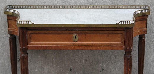 Antique console in the style of Louis XVI. Made of wood. Decorated with elements of brass. The table top is marble. France, XIX century.