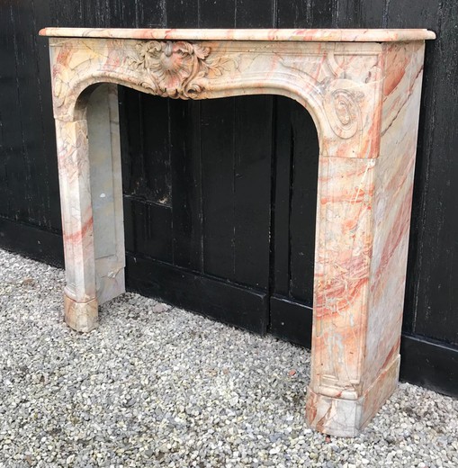 Antique fireplace portal in the style of Louis XV. It is made of marble Sarrankolin. France, XIX century.