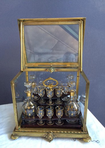Antique liquor set of four decanters and sixteen glasses in the style of Napoleon III. The case is made of gilded bronze and crystal glass. Europe, the XIX century.