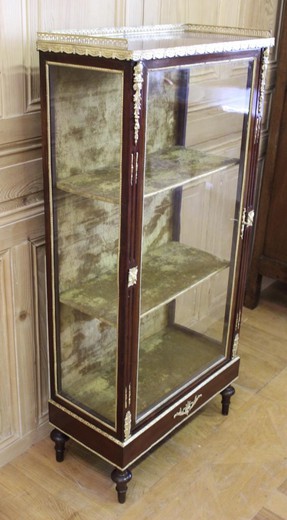 Antique showcase in the style of Napoleon III. It is made of mahogany. Decorated with patches of gilded bronze. France, XIX century.