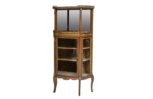 Antique showcase in the style of Louis XVI. It is made of walnut. Decorated with patches of gilded bronze. France, 1880s.
