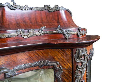 Antique showcase in the style of Louis XV. It is made of walnut. Decorated with plates of bronze. Europe, the 1880s.