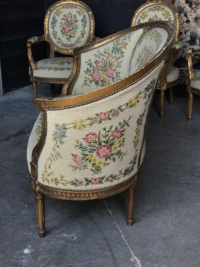 Antique set in the style of Louis XVI. The set includes a sofa and four armchairs. It is made of wood with gilding. France, XIX century.