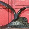Antique sculpture of a seagull on a wave