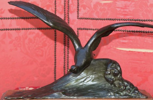 Antique sculpture of a seagull on a wave