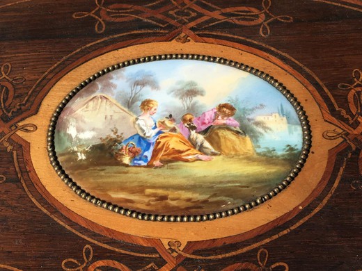 Antique jardiniere in the style of Napoleon III. Made from wood in marquetry. Decorated with patches of gilded bronze. On the lid is a decorative element from Sevres porcelain. France, XIX century.