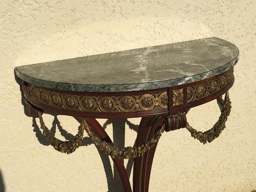 Antique console in the style of Louis XVI. Made of solid mahogany. Decorated with patches of gilded bronze. Table top made of gray marble "Saint Anne". France, XIX century.