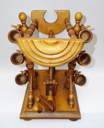 Antique mechanical bottle holder. It is made of wood. The slope of the bottle is adjustable. In a set of six wooden wine glasses. France, the 20th century.