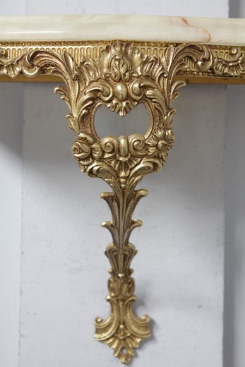 Antique console with a mirror in the style of Louis XV. It is made of gilded bronze. The console top is onyx. France, the middle of XX century.