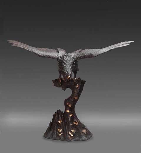 Antique sculpture of an eagle sitting on the top of a tree