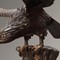 Antique sculpture of an eagle sitting on the top of a tree