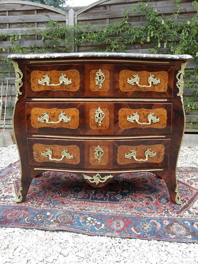 an antique chest of drawers in the Rococo style,