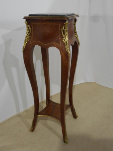 an antique pedestal of mahogany and bronze