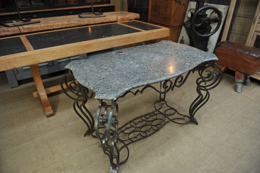 an antique metal table with marble