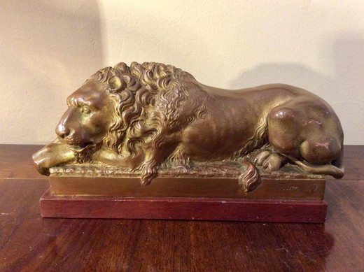 старинная скульптура лев из бронзы на красном мраморе
