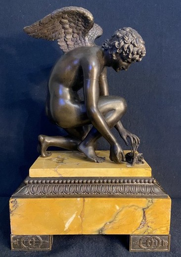 Antique sculpture "Cupid playing with a butterfly"
