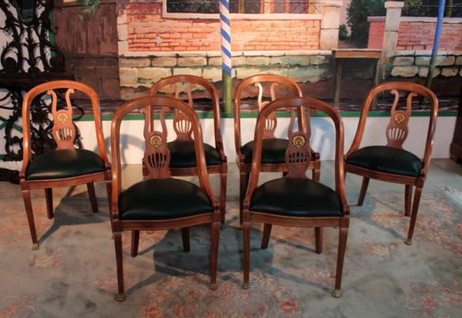 An ancient set of chairs in the Empire style. Made of mahogany, leather and bronze. Europe, the 1930s.