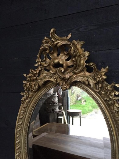 старинное овальное зеркало из дерева с позолотой