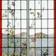 Antique stained glass window with birds and butterflies