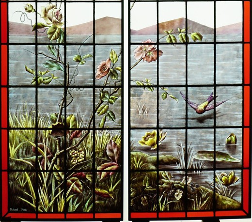 Antique stained glass window with birds and butterflies