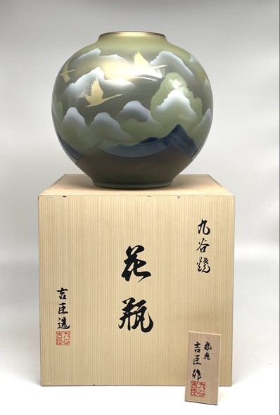 Vase with an image of flying cranes against a background of mountains