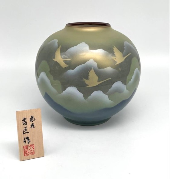 Vase with an image of flying cranes against a background of mountains