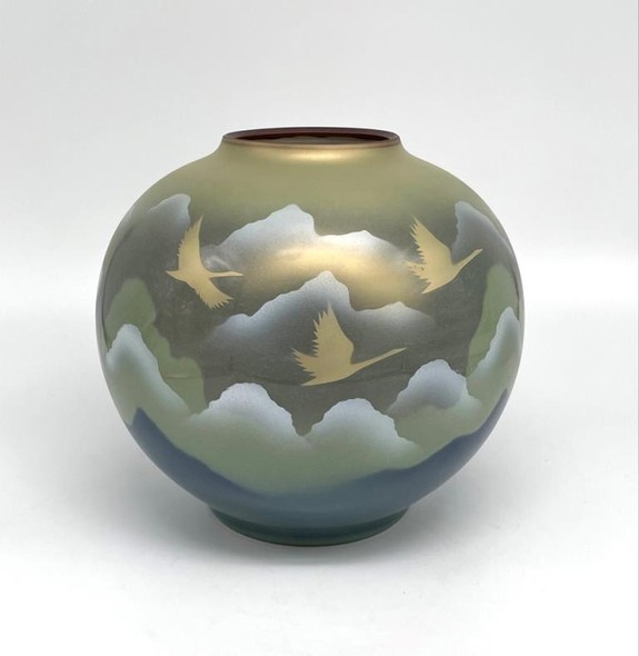 Vase with an image of flying cranes against a background of mountains