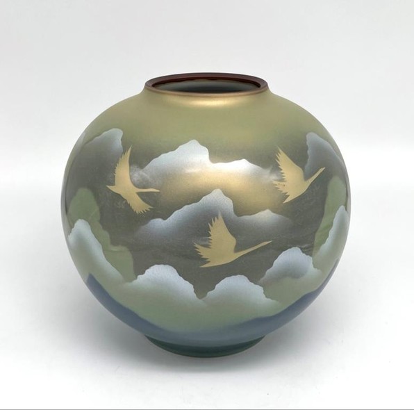 Vase with an image of flying cranes against a background of mountains