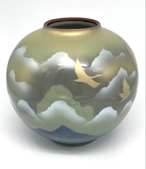 Vase with an image of flying cranes against a background of mountains