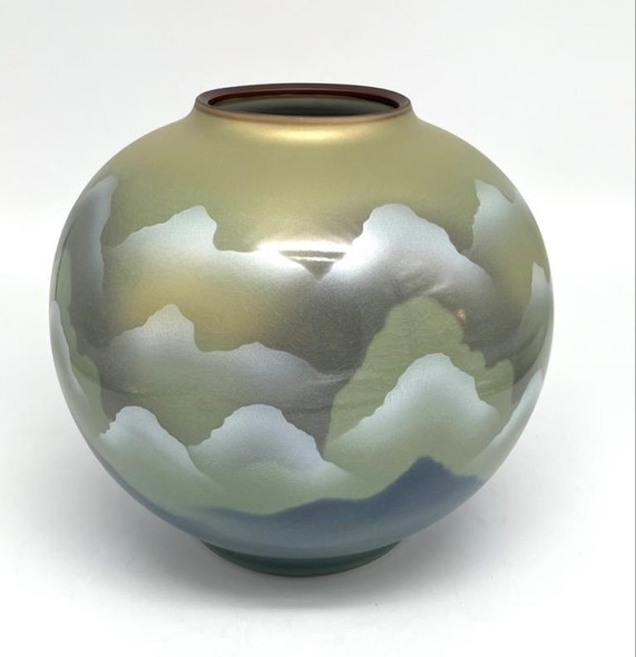 Vase with an image of flying cranes against a background of mountains