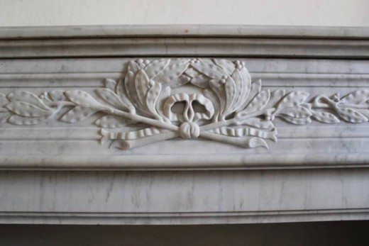 antique fireplace mantel made of white carrara marble with classical carving in Louis XVI style